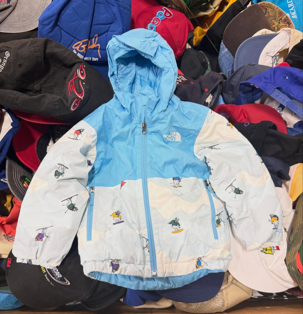 North Face jacket surrounded by vintage caps at Prime Rewind