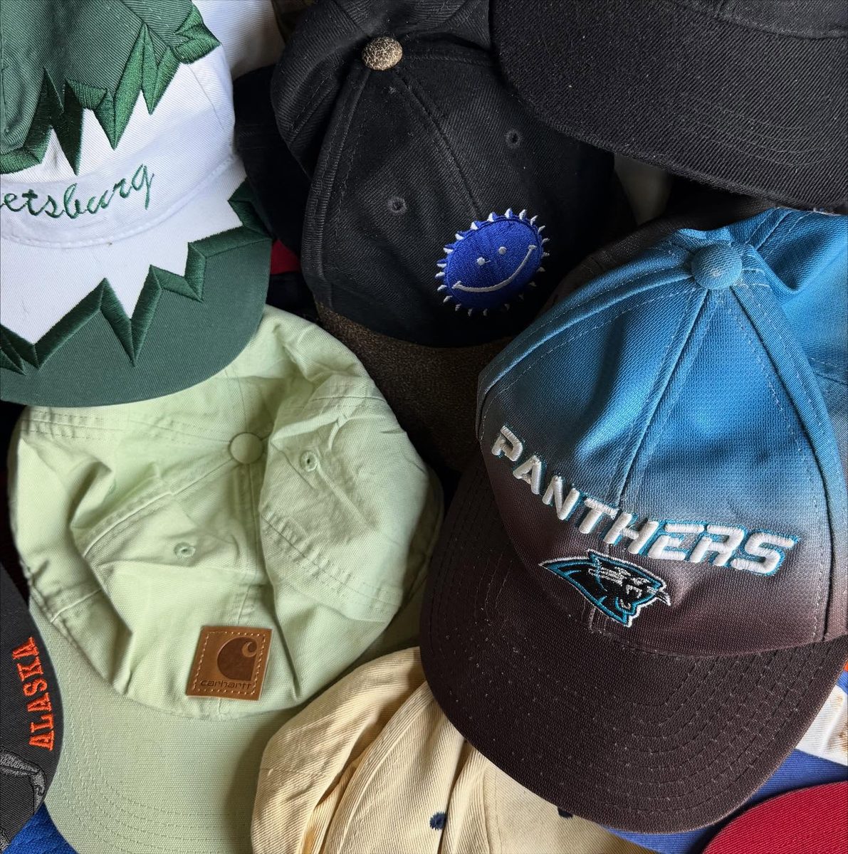 Close-up of vintage caps — Carhartt, Panthers, and more